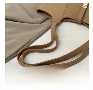 Close-up of wide comfortable shoulder straps and gold buckle on a brown tote bag