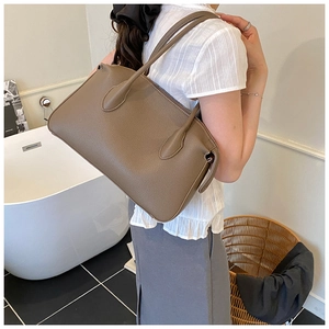 Dettaglio della pelle marrone con grana litchi su una borsa a tracolla alla moda
