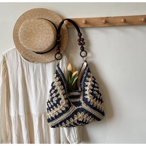 Detail of woven tote bag with geometric patterns and vintage wooden bead handles