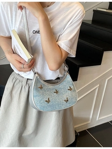 Borsa a tracolla a mezzaluna blu chiaro glitterata con farfalle d'argento su modella