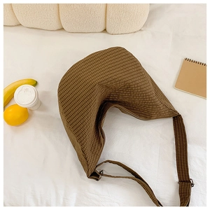 Detail der braunen karierten Hobo-Tasche aus Nylon mit verstellbarem Gurt auf Weiß