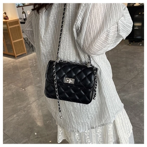 Detail of classic black quilted bag with silver twist-lock and chain shoulder strap