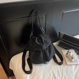 Dettaglio borsa a secchiello funzionale in nylon nero con coulisse e tasche esterne