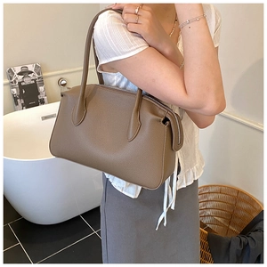 Borsa a mano in pelle marrone con grana litchi in un elegante scenario di lifestyle