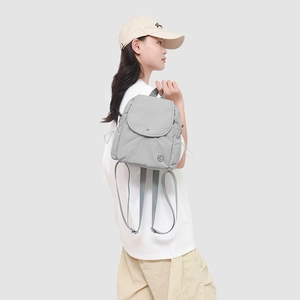 Gros plan du sac à dos en nylon gris clair imperméable avec cordons de serrage latéraux