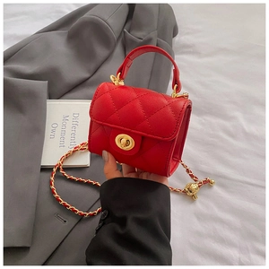 Close-up of red quilted leather mini bag with gold spherical charm and chain strap