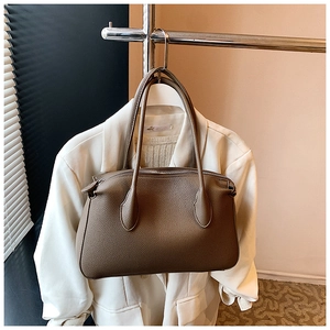 Dettaglio della pelle martellata marrone e chiusura lampo sulla borsa tote di moda