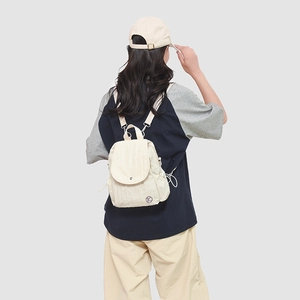 Vue détaillée du mini sac à dos en nylon beige plissé sur mannequin de dos