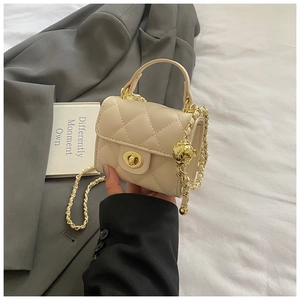 Detail of beige quilted mini bag with gold lock and metal ball chain strap accent