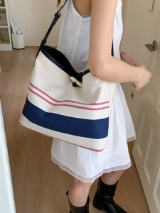 Large striped canvas tote bag with black leather straps and retro toggle button closure