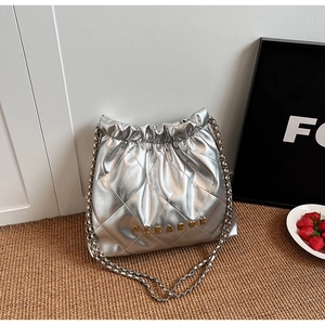 Detail of silver quilted bucket bag with metallic finish and metal chain strap