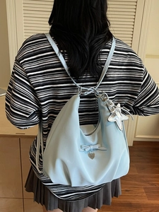 Chic light blue crescent backpack with bow detail and star pendant shown on model