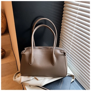Dettaglio della pelle martellata e cuciture premium di una borsa tote marrone