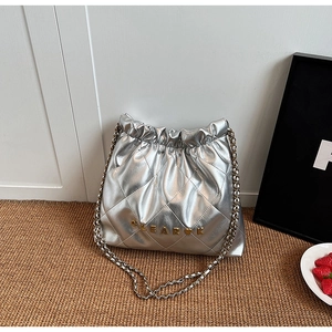 Close-up of quilted silver chain bag featuring gold GLEARK letter hardware and textures