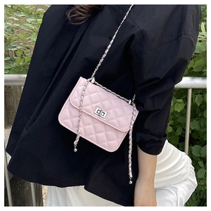 Close-up of pink quilted chain bag with silver twist-lock closure on model