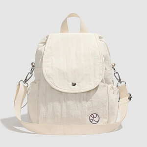 Détail d'un sac à dos convertible en nylon beige avec rabat et poches latérales