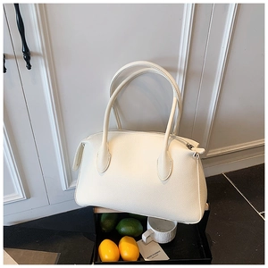 Dettaglio di una borsa sottobraccio bianca in pelle fiore litchi con manico sottile
