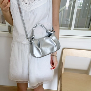 Close-up of a silver pleated cloud bag featuring metallic PU leather and a matching strap