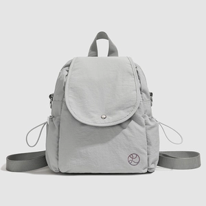 Détail d'un sac à dos gris clair résistant à l'eau avec texture froissée et logo rond