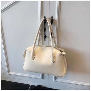 Dettaglio della borsa a spalla in pelle bianca con trama litchi e cerniera in metallo