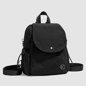 Vue détaillée du mini sac à dos en nylon noir avec poches latérales à cordon et boucle