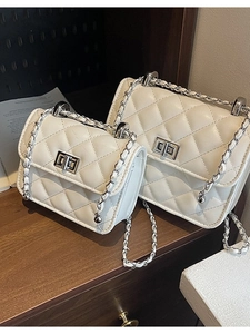Quilted white crossbody chain bags with silver locks in two sizes on wood surface