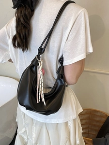 Bolso hobo media luna negro minimalista con correa anudada y colgantes laterales