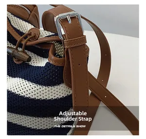 Detail show of adjustable brown leather shoulder strap on striped woven bucket bag