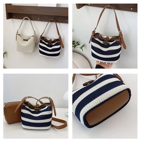 Detail of woven straw bucket bag with navy stripes, leather strap and horn toggle button