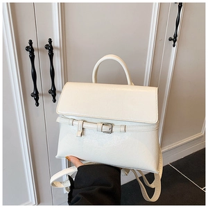 Detailed view of cream-white synthetic leather texture and silver buckle on a versatile bag