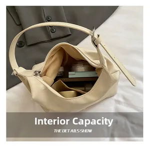 Internal capacity of beige minimalist underarm bag with makeup essentials inside