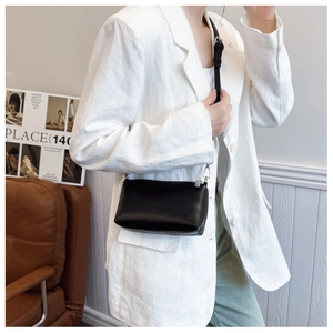 Minimalist black rectangle crossbody bag shown on model wearing a white casual blazer