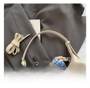 Detail of cream leather shoulder bag with fine texture and stylish plush charm accessory