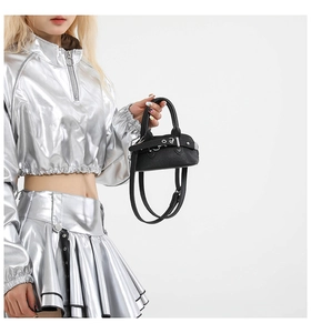 Detail of mini black litchi pattern shell bag with silver buckle and crossbody strap