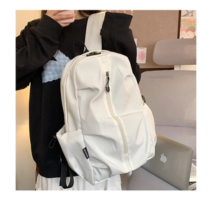 Detail of white minimalist backpack featuring vertical offset zipper and brand logo