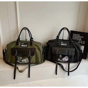 Detail of army green and black travel duffel bags with dual rivets and sturdy handles