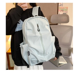 Detail view of water-resistant nylon backpack with vertical zipper and side woven tag