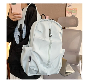 Close-up of mint blue water-resistant backpack showing side pockets and zipper detail