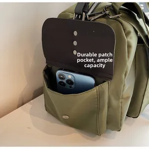 Detail of army green canvas travel bag side pocket showing phone storage capacity