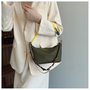 Detail of olive green canvas handbag showing unique yellow rope and leather strap texture
