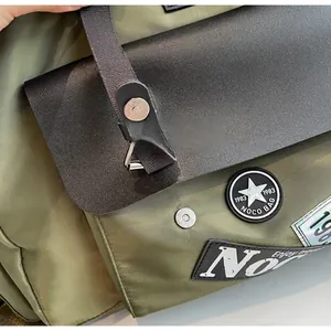Detail of army green nylon bag featuring vintage star patch and secure metal buckle