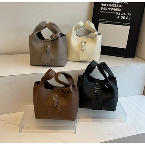 Sacs seaux en cuir grainé en coloris taupe, beige, marron et noir exposés en groupe