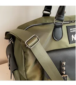 Detail of army green nylon travel bag featuring adjustable black shoulder strap and buckle