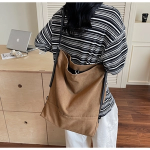 Detail of a large canvas bucket bag with wide capacity and a black shoulder strap
