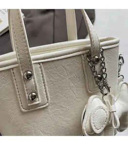 Detail of white PU leather bucket bag with vintage texture and silver rivet studs