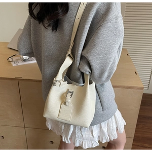 Vue détaillée du sac seau en cuir grainé blanc cassé avec des finitions en métal argenté
