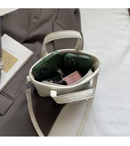 Interior view showing the capacity of white pebble leather mini tote bag with personal items