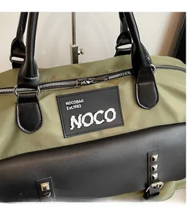 Detail of green canvas gym bag with NOCOBAG logo and premium metal rivet accents
