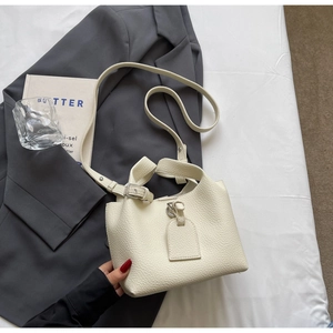 Détail d'un sac à main blanc crème en cuir grainé avec boucle argentée et bandoulière