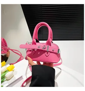 Detail of rose pink pebbled leather mini handbag with silver hardware and chic belt accent